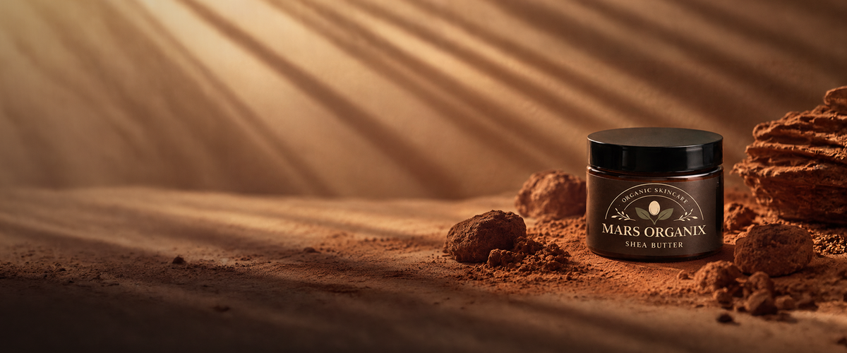 A jar of Mars Organix Shea Butter set on a sandy desert-like surface with rocks and warm light rays in the background.