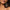 Close-up of a person's face and shoulder with water droplets, holding a jar of Mars Organix Shea Butter against the skin. The jar is dark brown with a black lid and a brown label featuring the Mars Organix logo.
